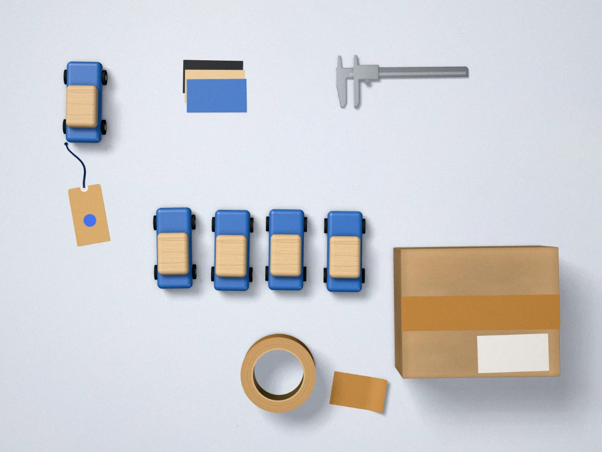 An approved sample toy car, colour chips, a caliper, four matching production units and a taped shipping carton on a sample table
